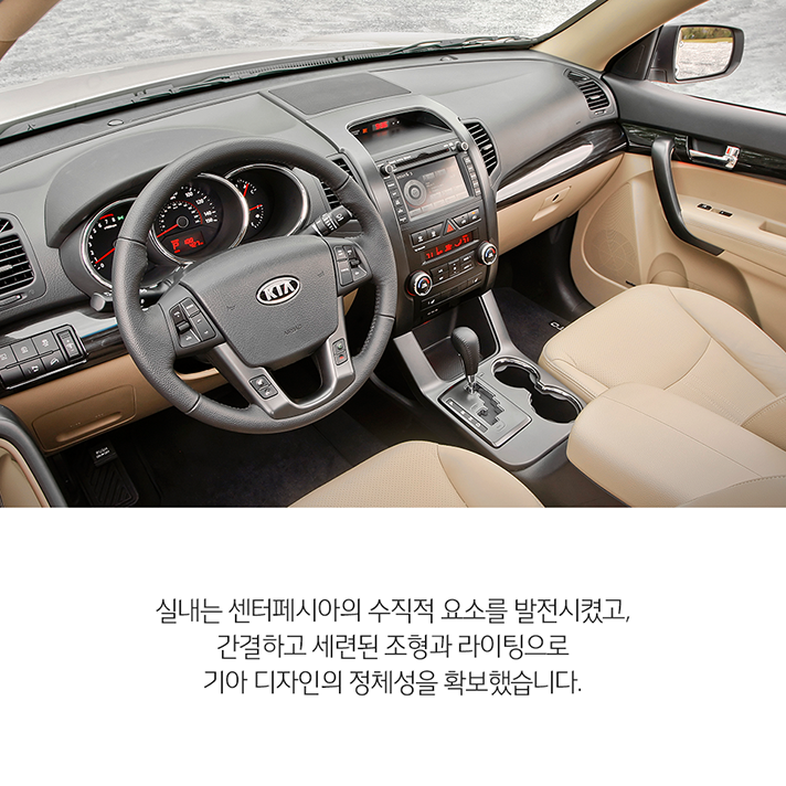 상단 2세대 쏘렌토 실내 이미지와 하단 문구 - 실내는 센터페시아의 수직적 요소를 발전시켰고, 간결하고 세련된 조형과 라이팅으로 기아 디자인의 정체성을 확보했습니다.