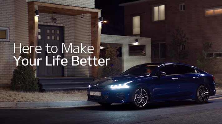 기아차를 타고 집 앞에 도착한 부부, Here to Make Your Life Better 카피 문구가 좌측 공간에 표기되어 있다