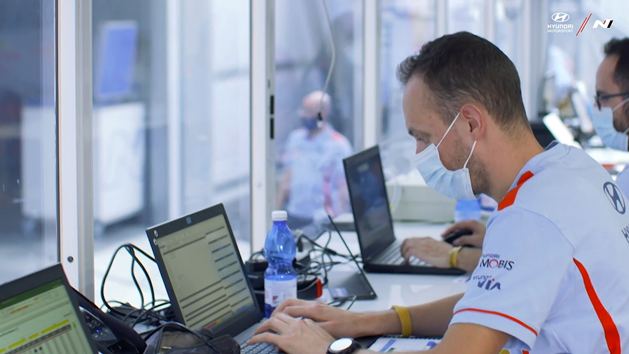 Two engineers sorting racing data on management truck