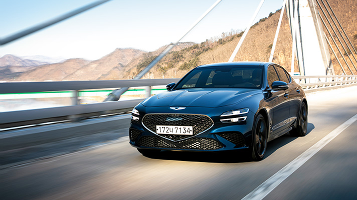 Front side Angle view of tasman blue Genesis G70 driving on bridge