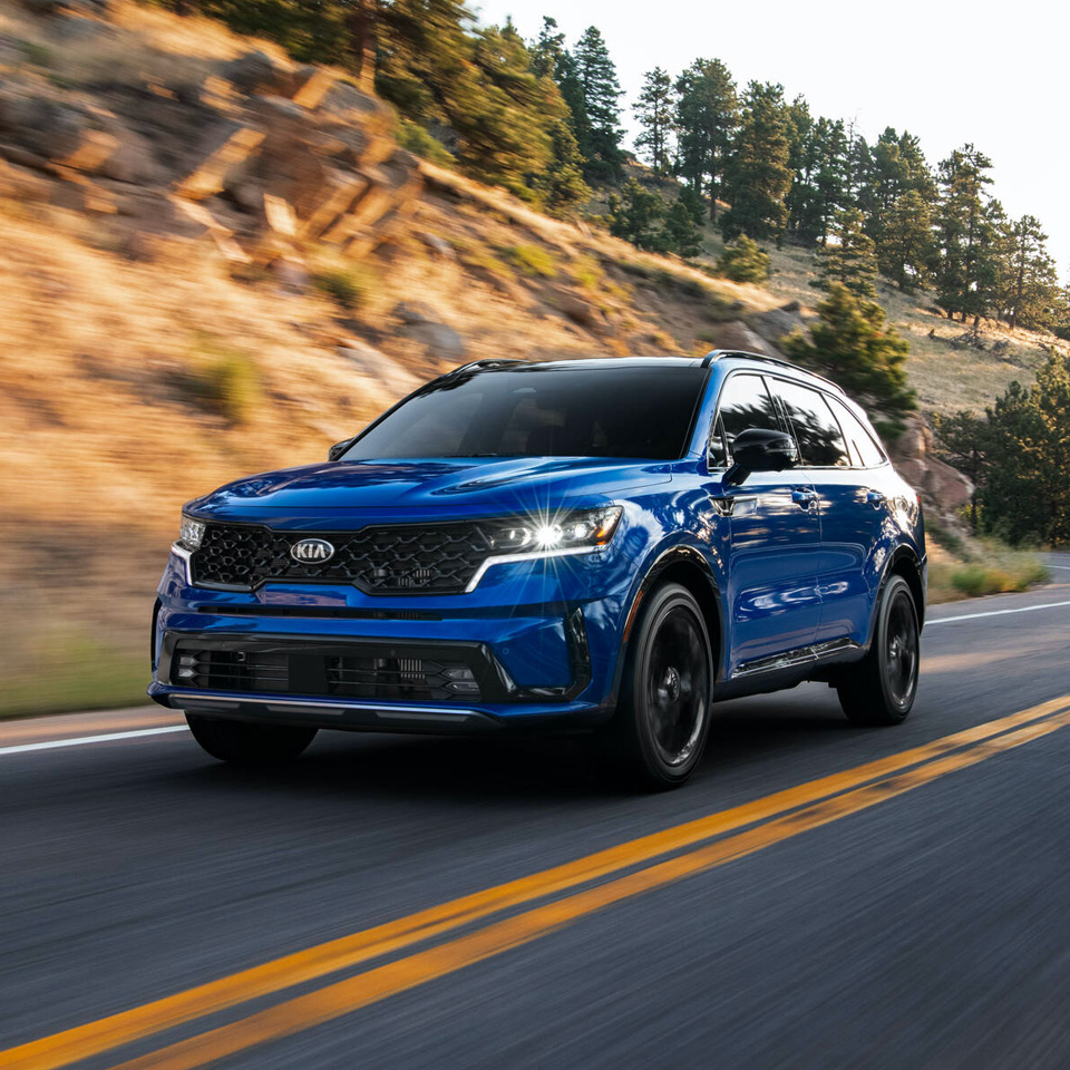 도로를 주행중인 미네랄 블루 색상의 기아 쏘렌토