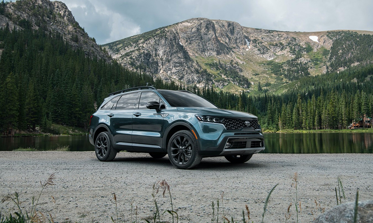 호수 앞에 서있는 사파이어 블루 색상 기아 쏘렌토의 모습