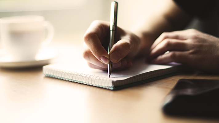 스프링 노트에 글을 적고 있는 모습