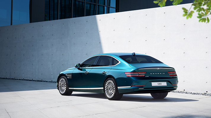 햇빛을 받으며 서 있는 제네시스 G80 후면