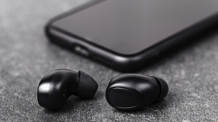 검은색 무선 이어버드와 스마트폰