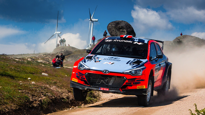 A rally car running on an unpaved road