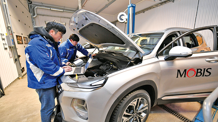 2명의 현대모비스 엔지니어가 테스트 차량의 보닛을 열고 결과를 분석하고 있는 모습