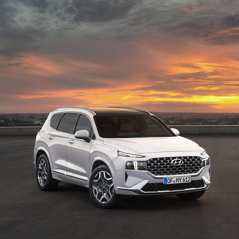 노을 배경에 서 있는 2대의 현대자동차 싼타페