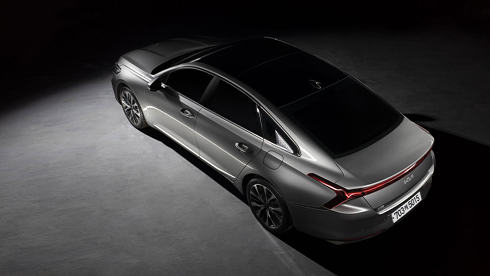 어두운 배경의 기아 K8 탑 뷰