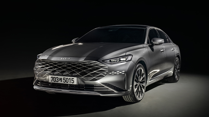 어두운 배경의 기아 K8 정면