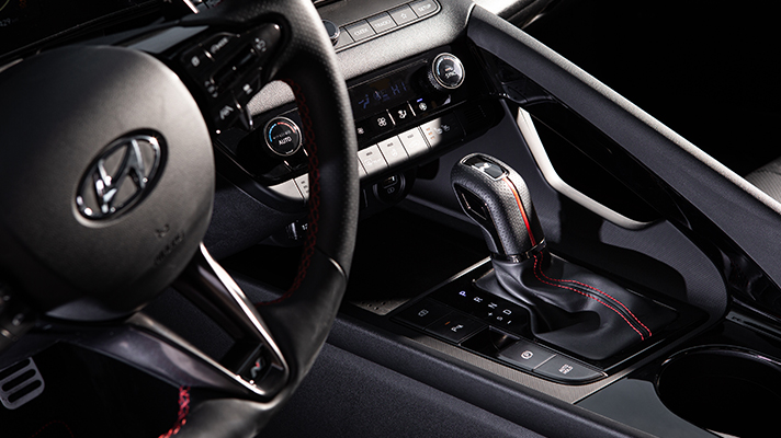 붉은 색 스티치가 들어간 아반떼 N 라인의 기어 노브와 스티어링 휠
