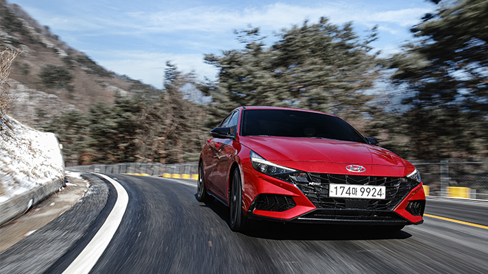 Front view of red Hyundai Elantra N Line driving on mountain roads