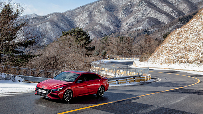 Angle view of red Hyundai Elantra N Line driving on mountain roads