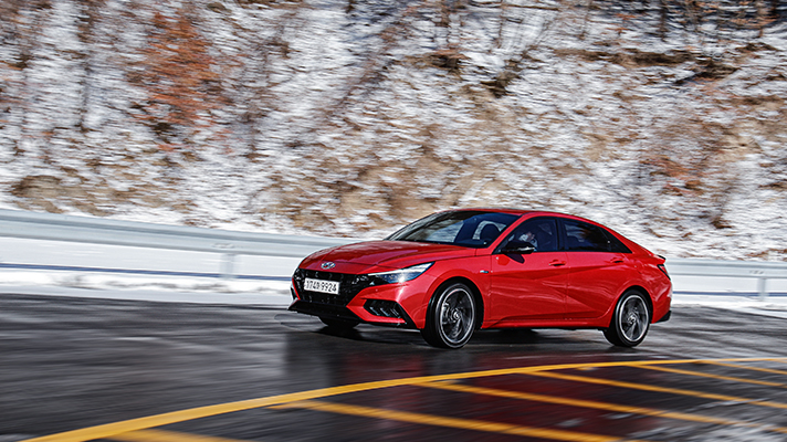 Angle view of red Hyundai Elantra N Line driving uphill