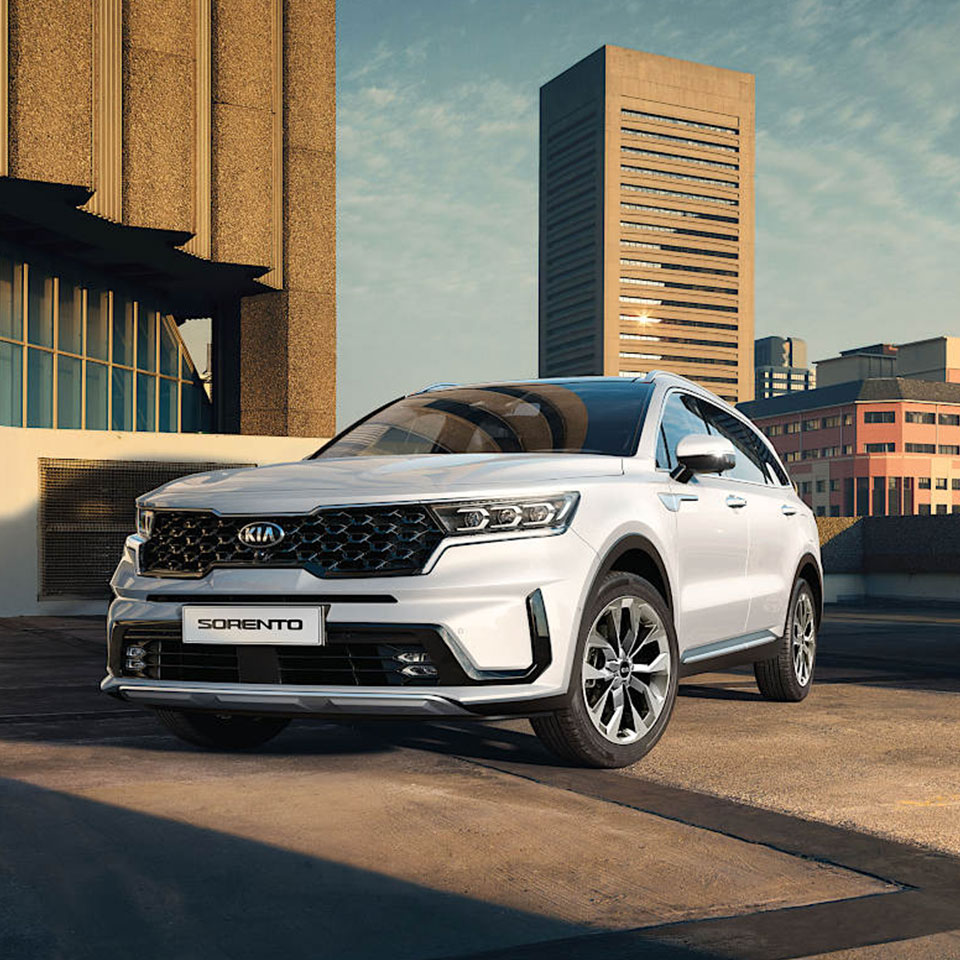 고층 빌딩 앞 주차되어 있는 두 대의 기아 쏘렌토 모습