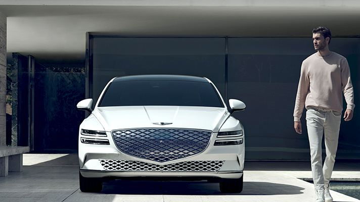 제네시스 G80 전동화 모델의 정면 모습과 남성