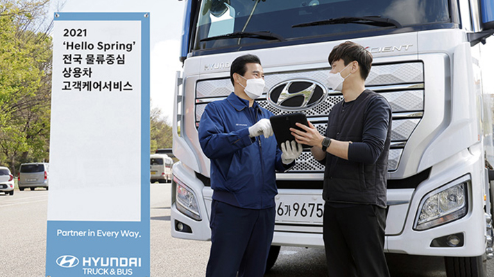 현대자동차 엑시언트 앞에서 정비사와 운전자가 대화를 나누고 있는 모습