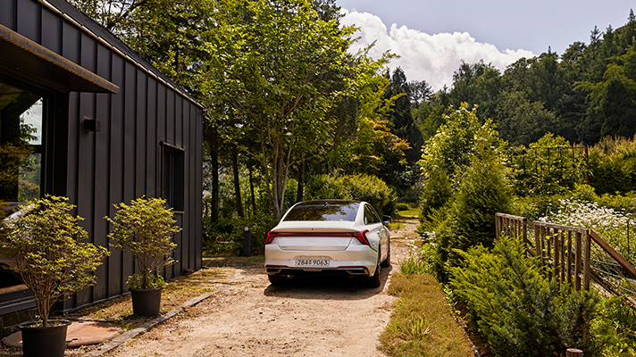 Rear view of Kia K8 parked in the garden