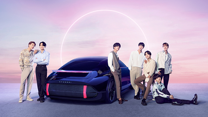 BTS 멤버가 현대자동차 아이오닉과 함께 서 있는 모습