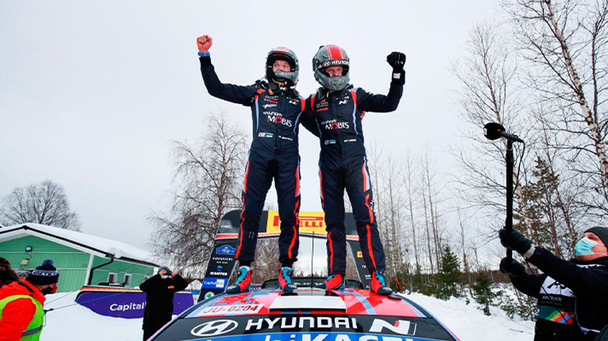 View of Ott Tanak and his co-driver on roof of racing car rally finish
