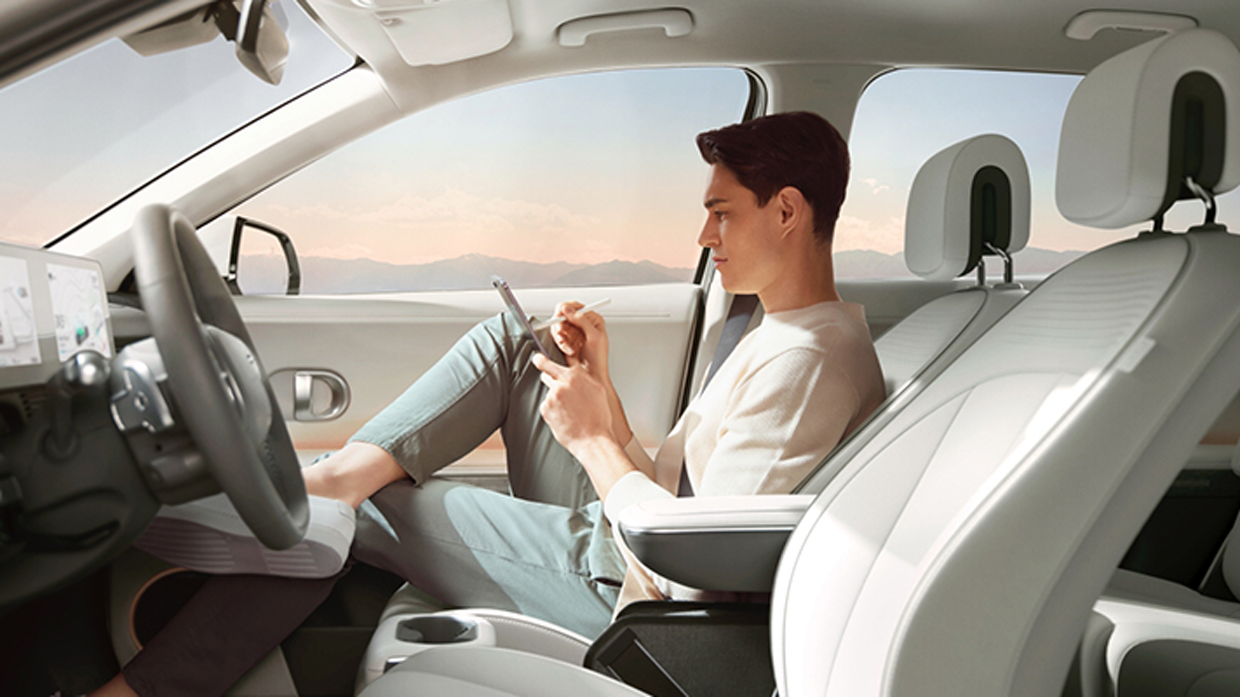 아이오닉 5 보조석에서 태블릿을 보고 있는 승객