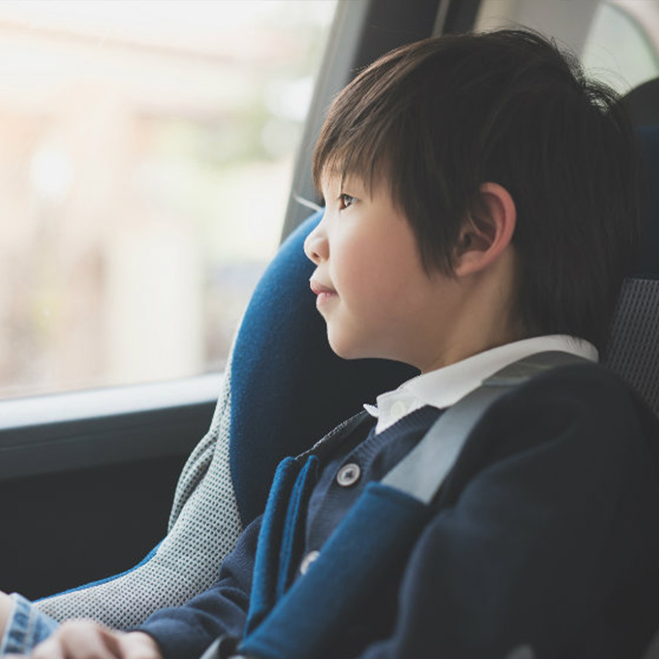 Child sitting in a car seat and looking out