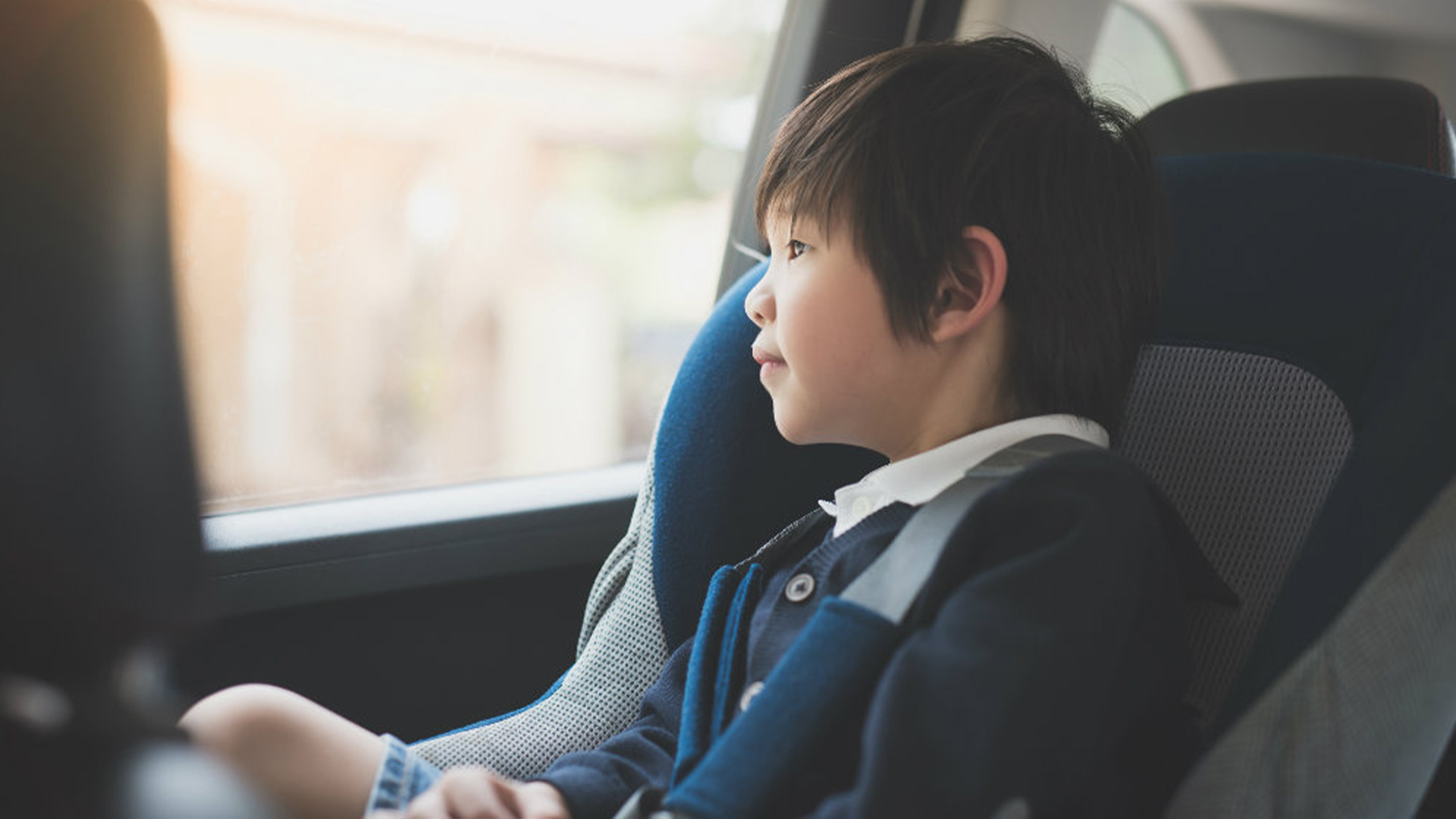 Child sitting in a car seat and looking out