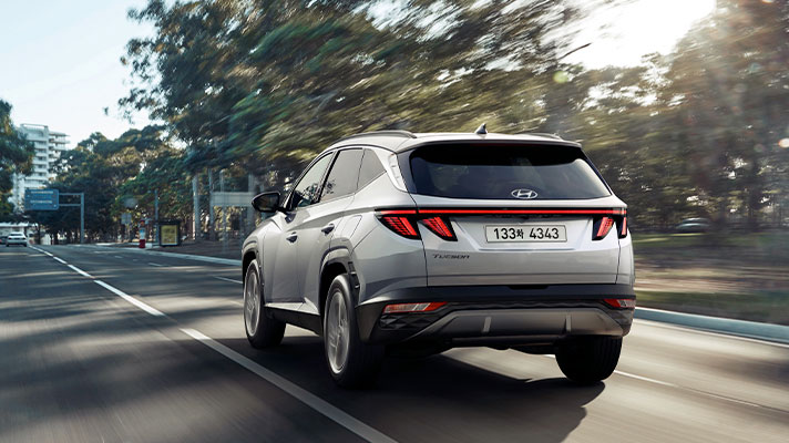 Rear view of hybrid car running on the road