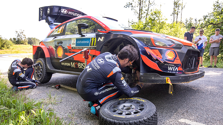 Driver and co-driver changing a rally car tire
