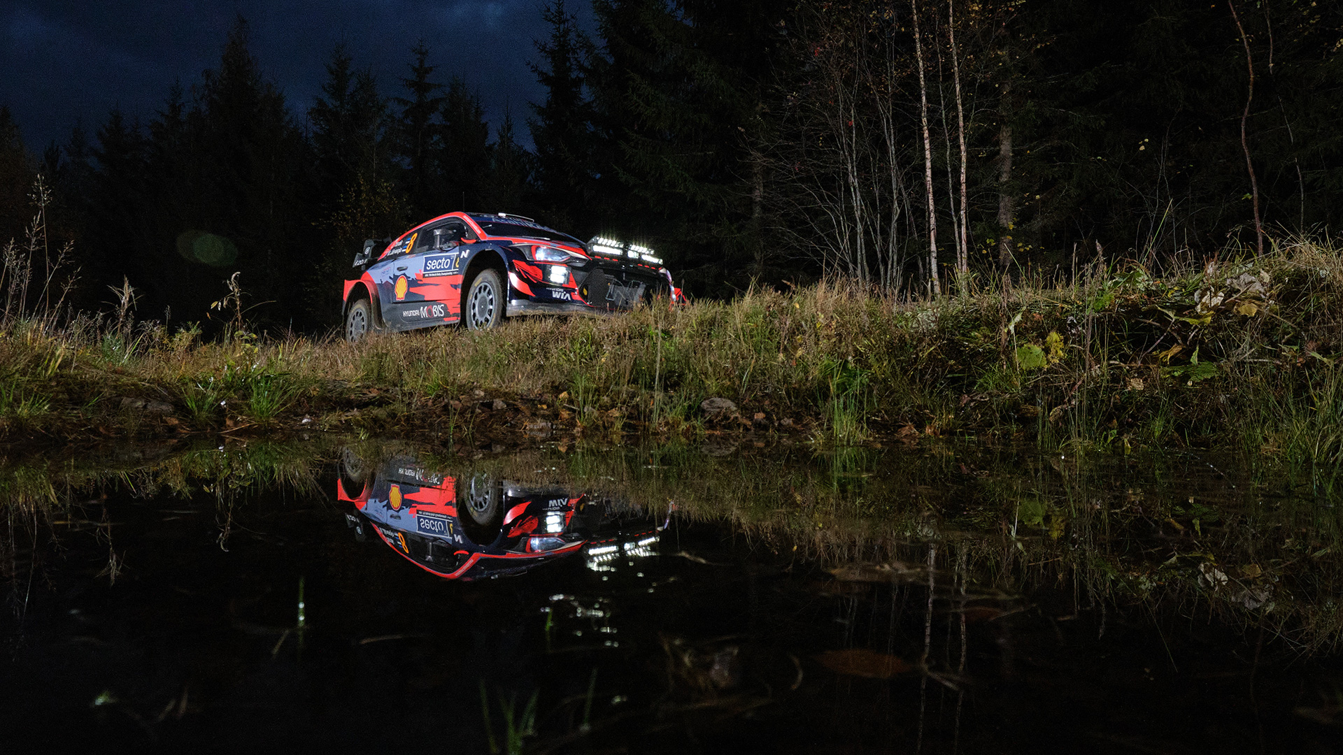 Side of WRC rally car driving on dirt road