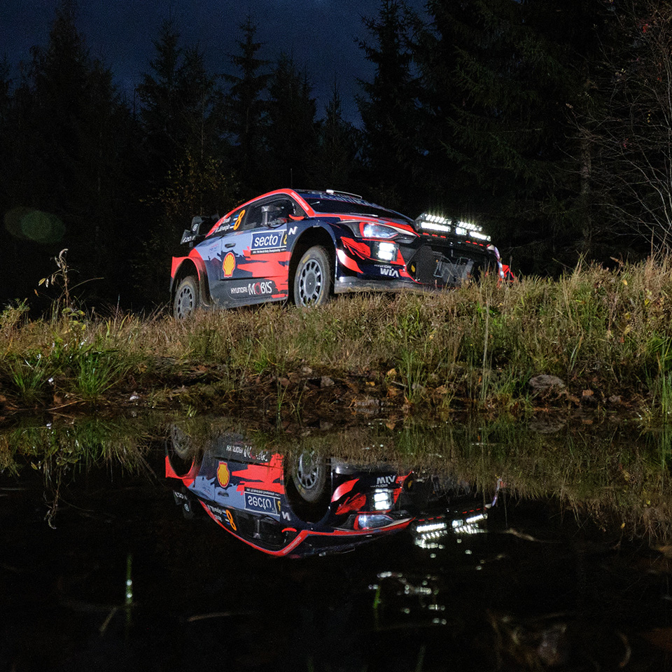 어둠이 짙게 깔린 비포장도로를 달리는 WRC car 측면