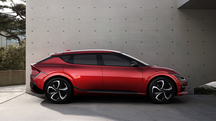 건물 앞 주차된 레드 기아 EV6 측면 모습