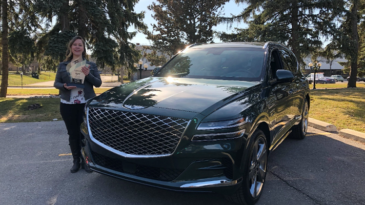 캐나다 자동차 기자 협회장이 트로피를 들고 제네시스 GV80 앞에 서 있는 모습