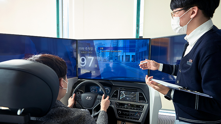 주행을 연습하는 체험자에게 전문강사가 설명하고 있는 모습