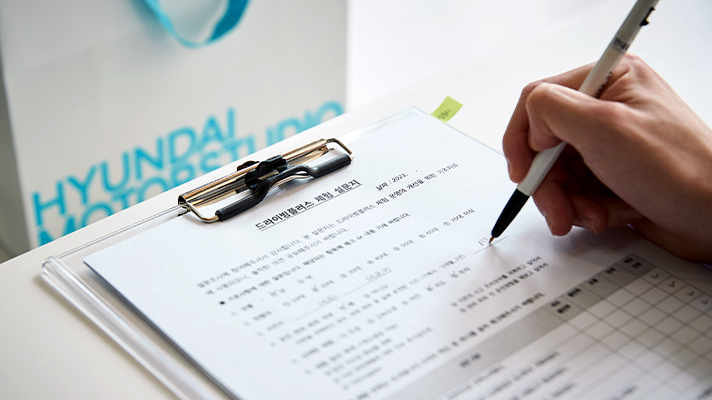 드라이빙 플러스 체험 설문지를 작성하는 모습