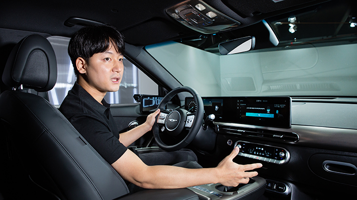 GV60 운전석에 앉아  지문 인식 기술에 대해 설명하는 이용석 연구원