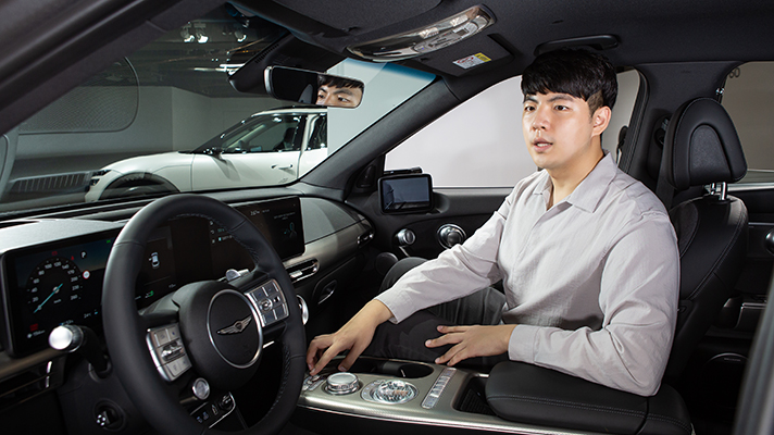 GV60 운전석에 앉아  지문 인증 시스템에 대해 설명하는 한의성 연구원