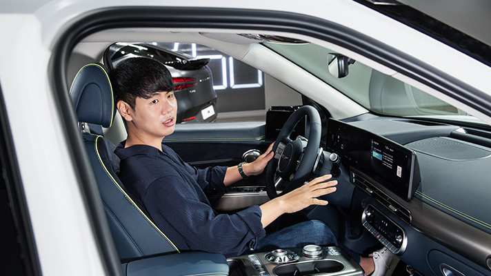 Senior Manager Daeil Seo of the OTA general team sitting in the driver's seat of the GV60 and interviewing