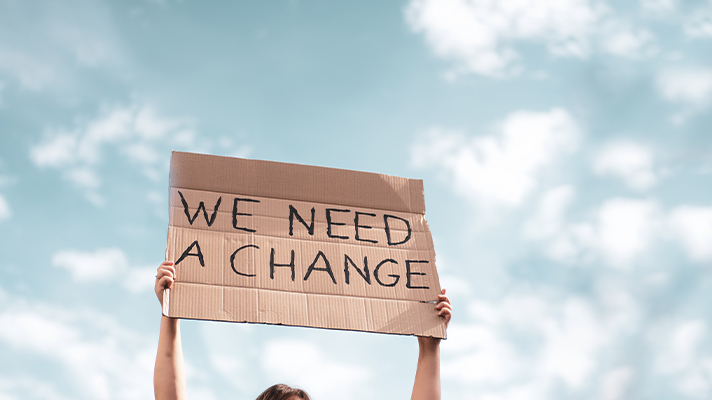 피켓을 들고 있는 모습. We Need A Change.