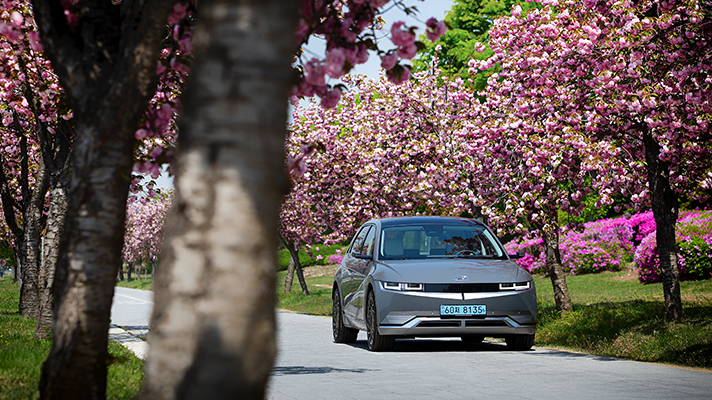 Hyundai IONIQ 5 running on a road in bloom