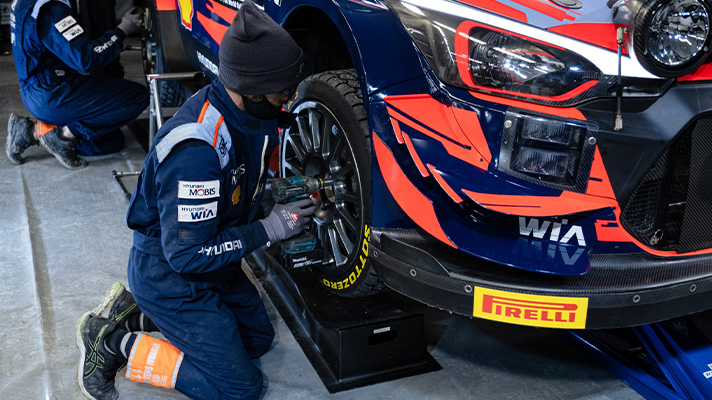 Installing new tires on racing car at service park