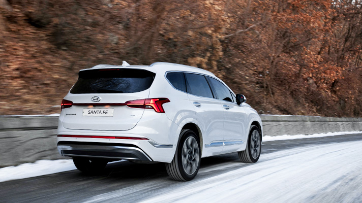 White Hyundai Santa Fe driving on snowy road