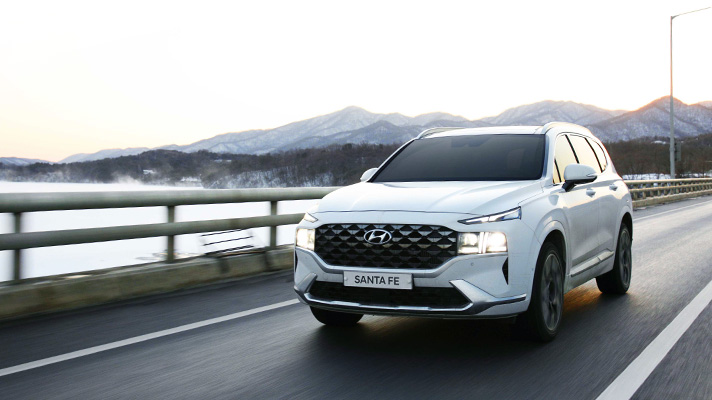 White Hyundai Santa Fe driving on road