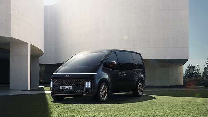 잔디밭에 주차된 현대자동차 스타리아 측면 앵글 뷰