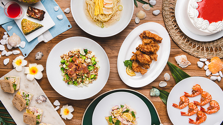 Top view of a variety of Hawaiian local food placed on a wooden table