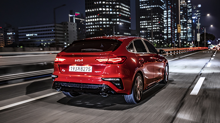 Rear view of Kia K3 GT running at night city