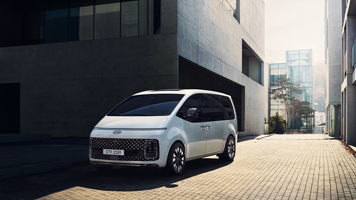 빌딩 앞 흰색 현대자동차 스타리아