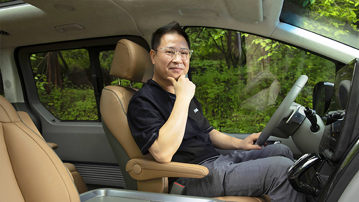 Jinhyuk Seo sitting in the driver seat of Hyundai STARIA
