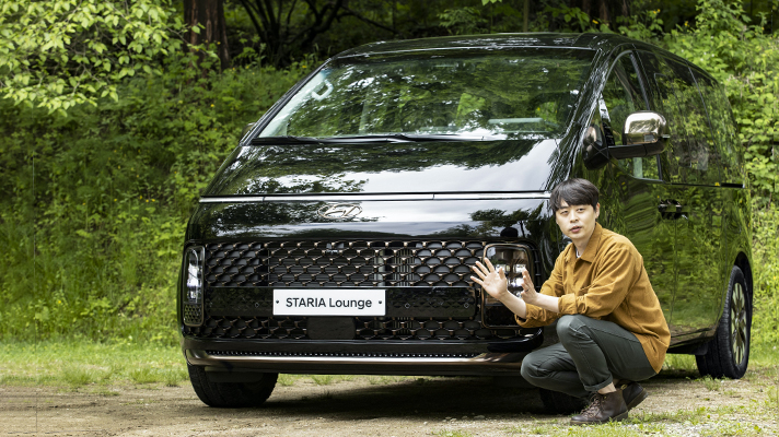 Jun Seo giving an explanation while sitting in front of Hyundai STARIA