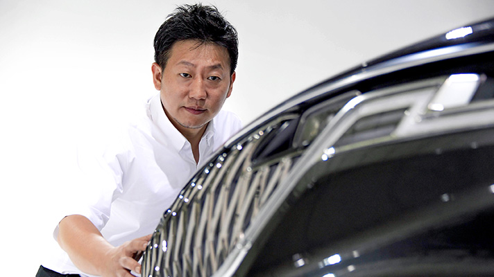 Senior Research Engineer Park Jung-Yong, responsible for exterior design looking at the radiator grille of 4th-gen carnival